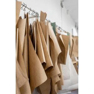 A collection of paper sewing patterns hanging in a bright fashion studio interior.